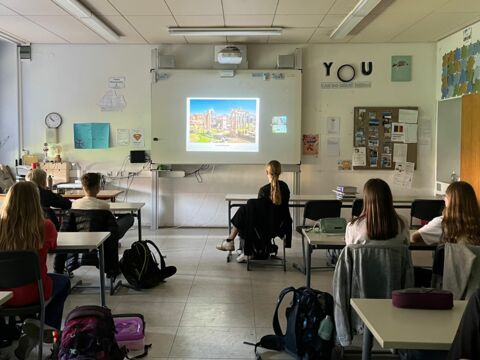 Schüler:innen hören der online zugeschalteten Archäologin zu und sehen sich den geteilten Bildschirm an.